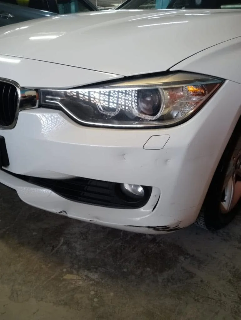 BMW with visible dent before repair